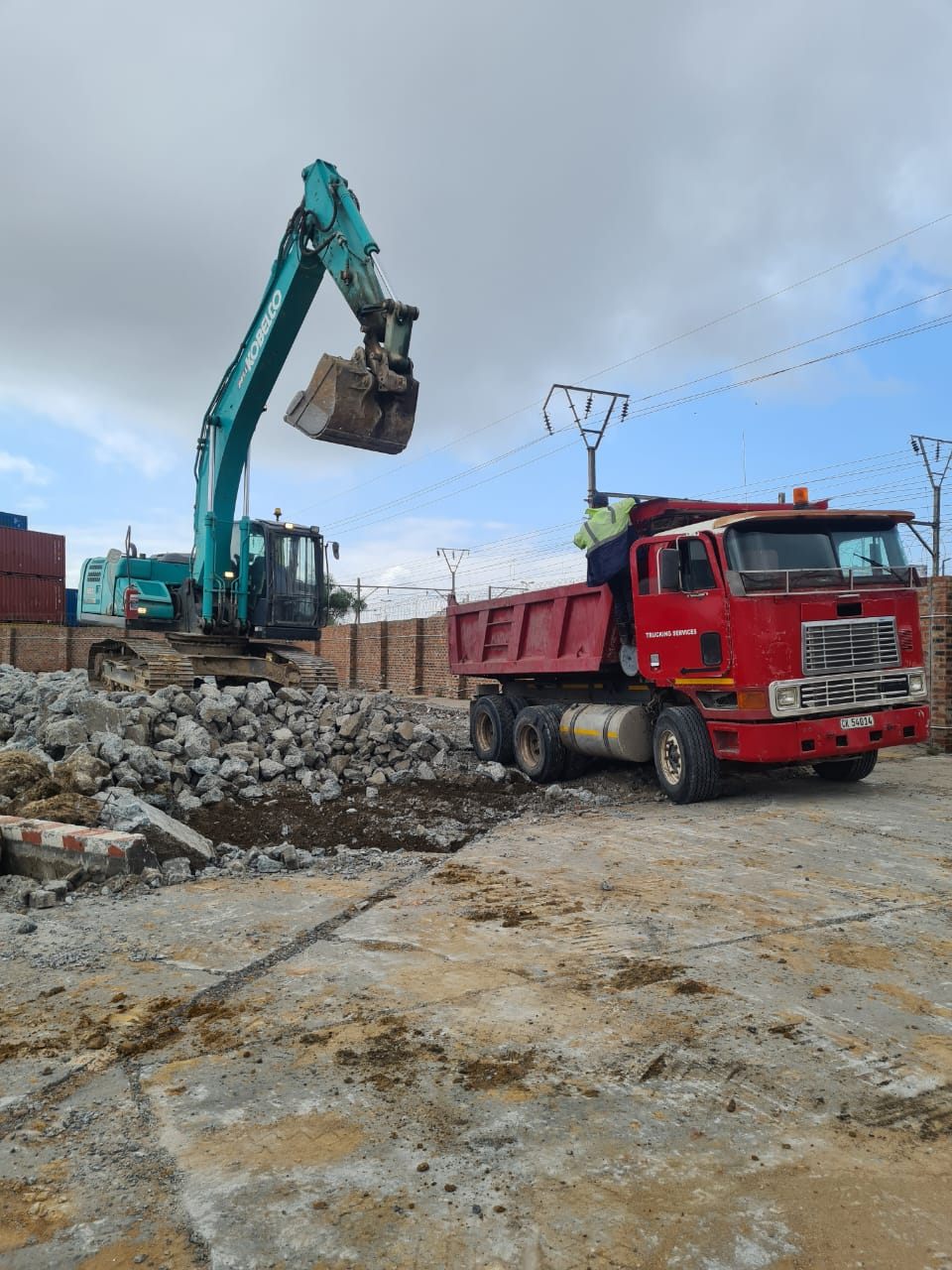Tipper truck and excavator clearing a site